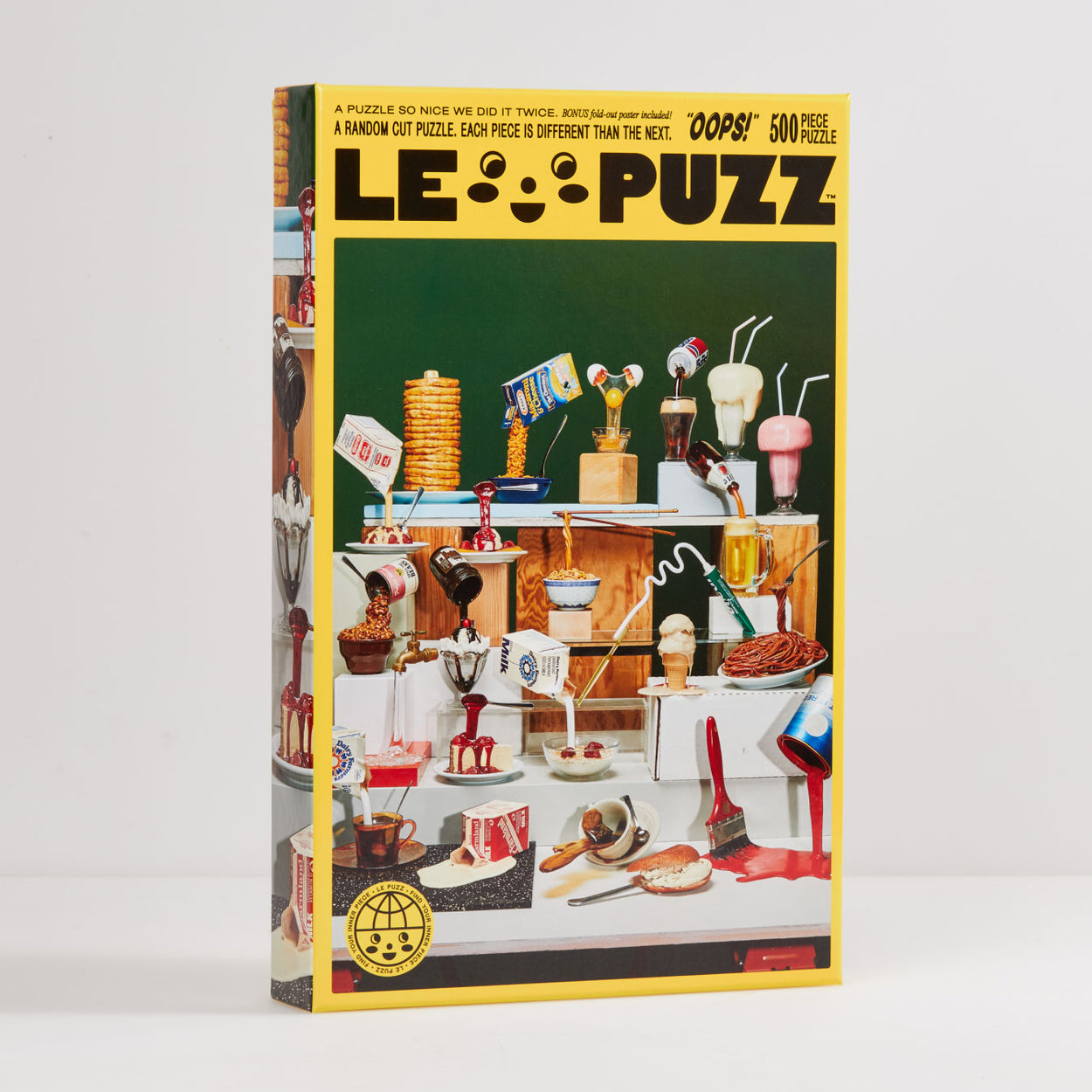 Oops Puzzle | Le Puzz | 500 Pieces: Oops is an homage to one of our favorite oddities — Frozen Moments! These wonderfully weird fake food objects are a moment frozen in time. We even tracked down their original creator Geoffrey Rose (see back of box for an exclusive interview).